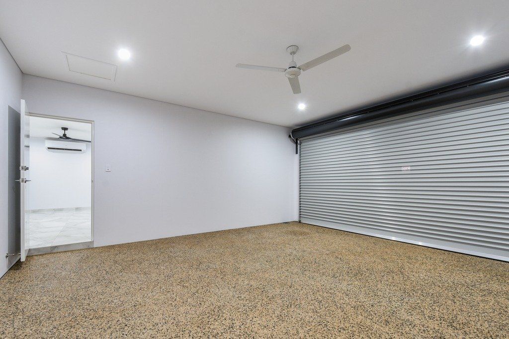 An empty garage with a ceiling fan and a door.