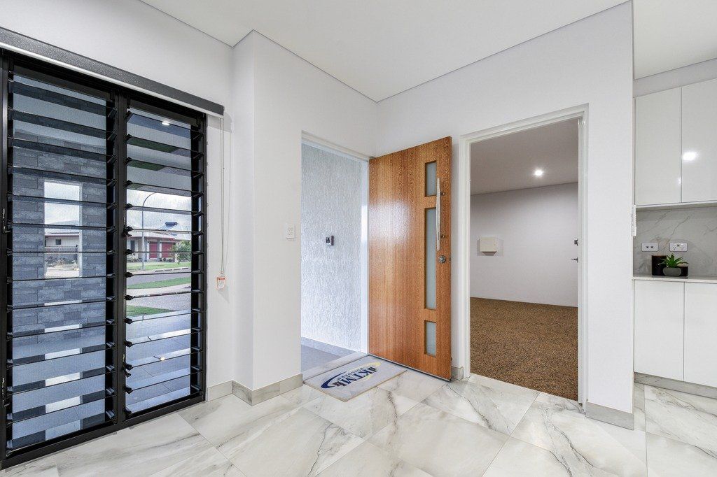 An empty room with a wooden door and a marble floor.