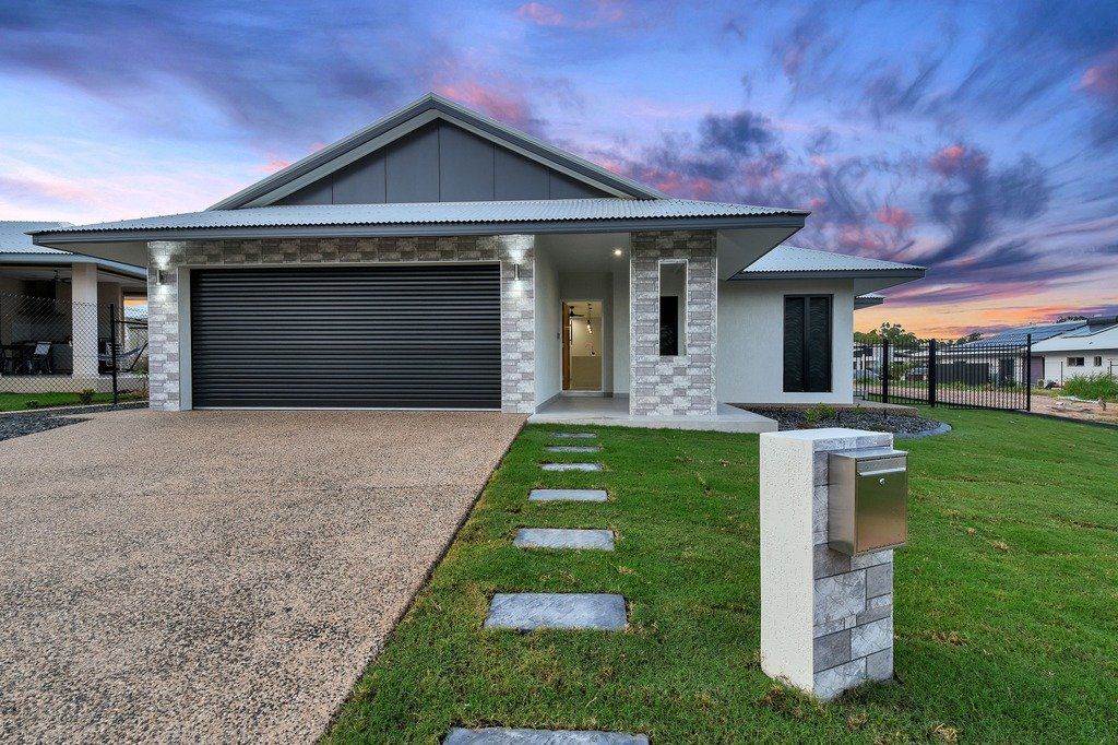 A house with a black garage door and a mailbox in front of it.