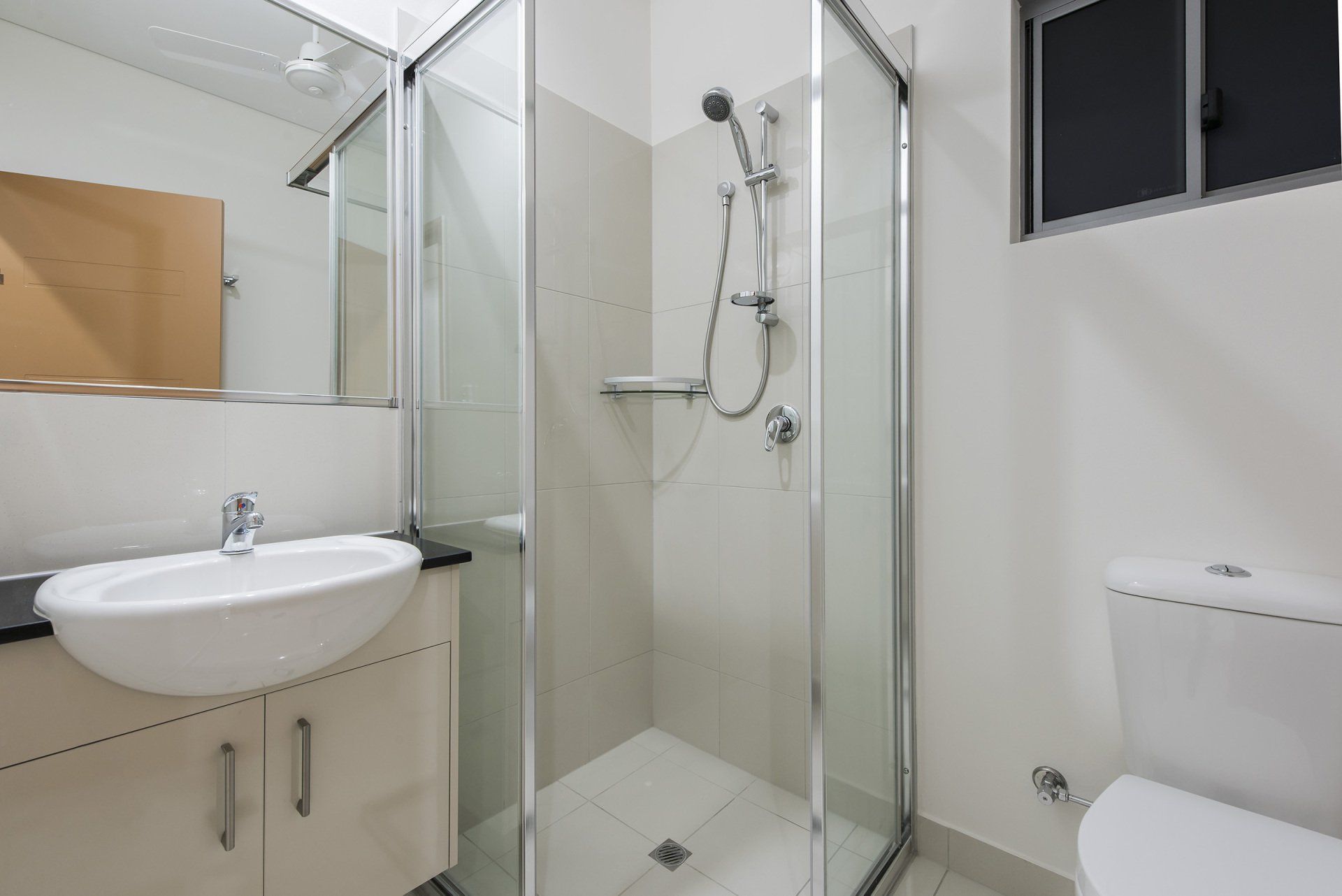 A bathroom with a sink , toilet , shower and mirror.
