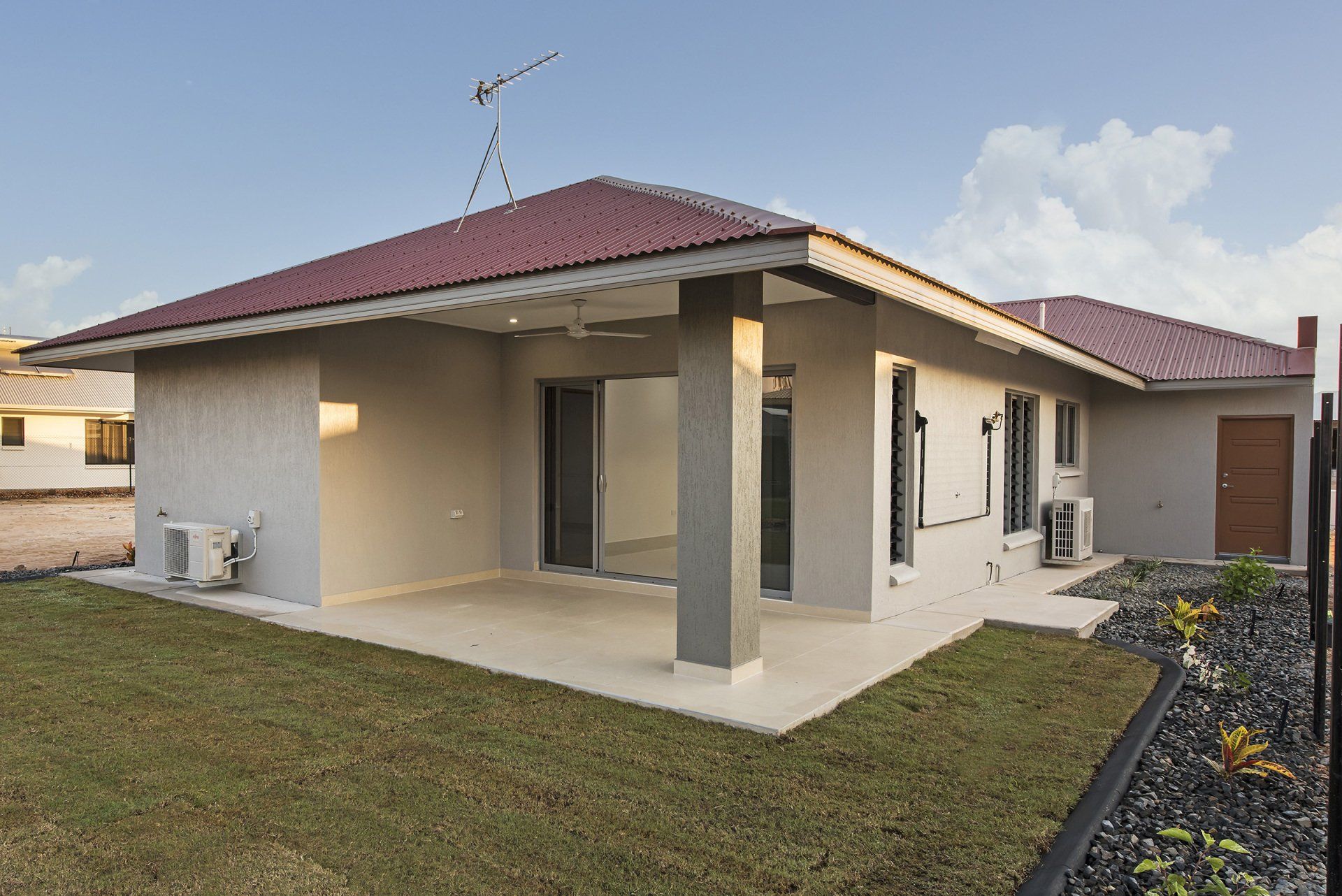 A house with a red roof and a patio in front of it