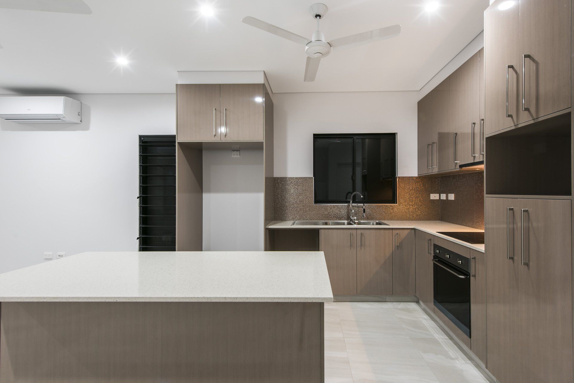 A kitchen with a large island and a ceiling fan