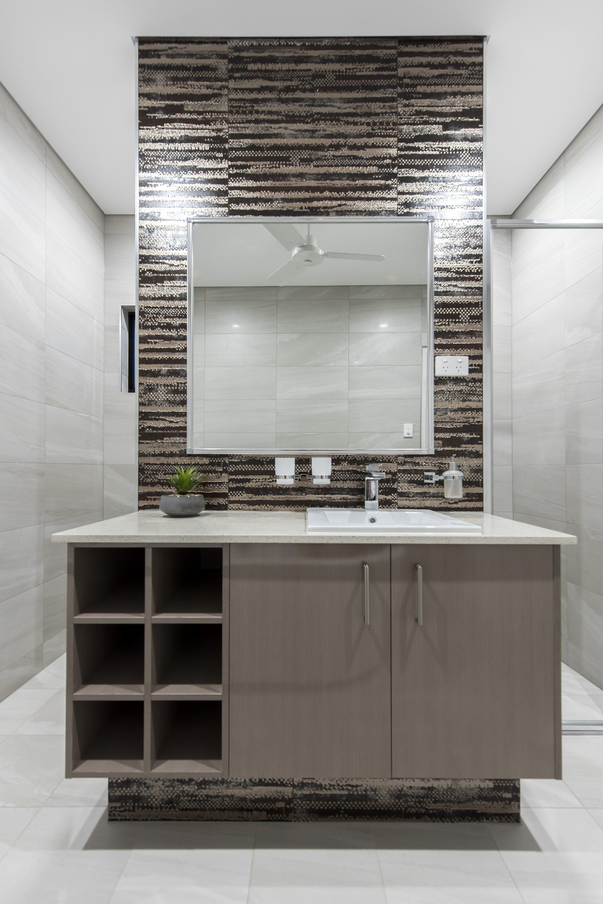 A bathroom with a sink , mirror and cabinets.