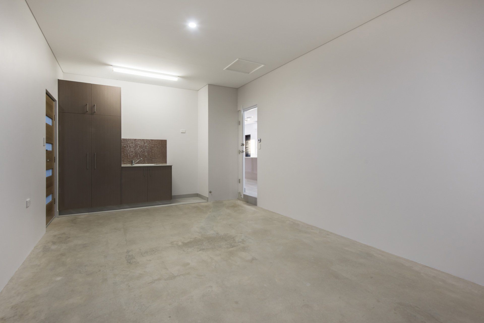 An empty room with a concrete floor and white walls.