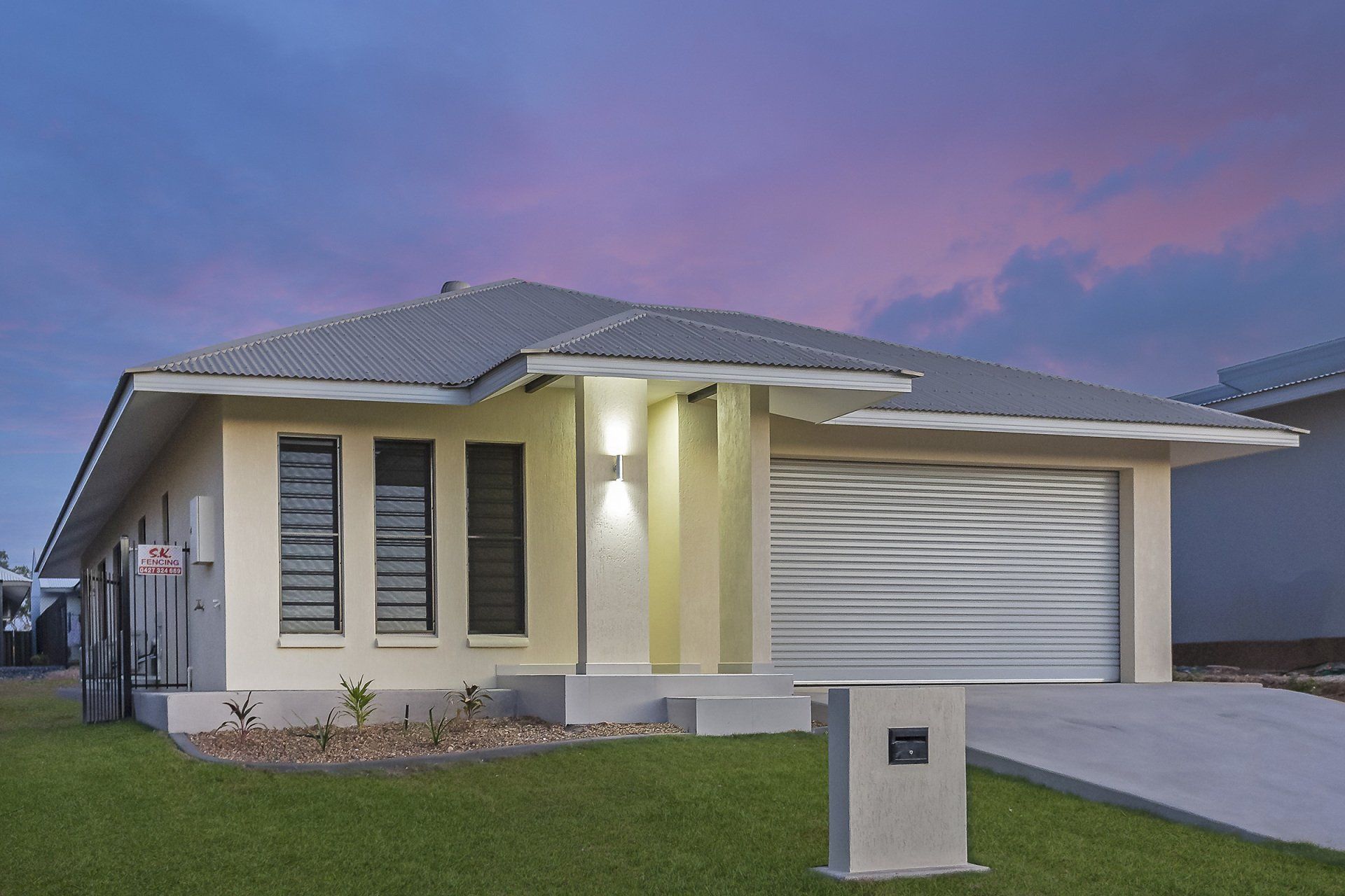 A house with a gray roof and a white garage door