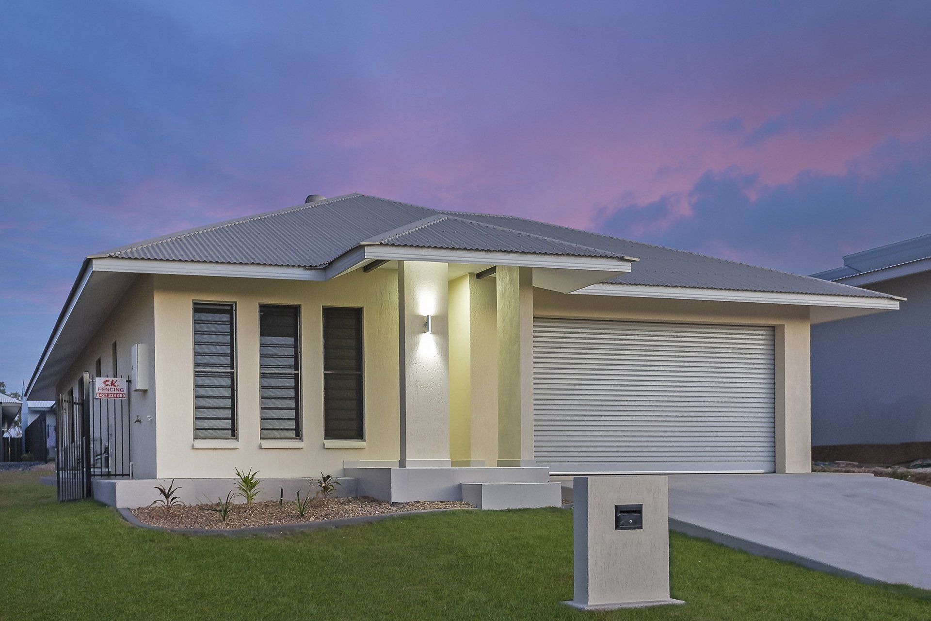 A house with a gray roof and a white garage door