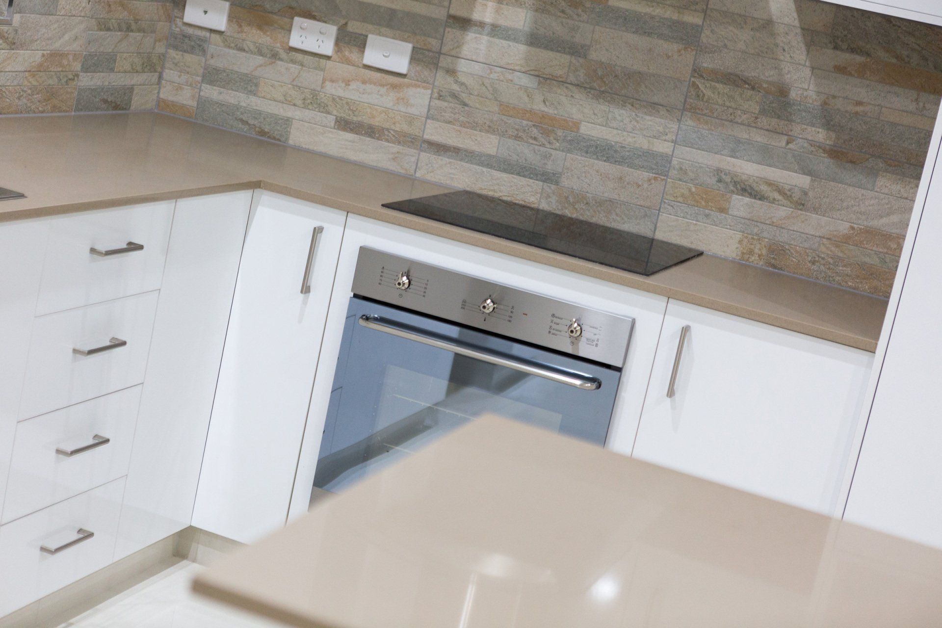A kitchen with white cabinets and a stove top oven