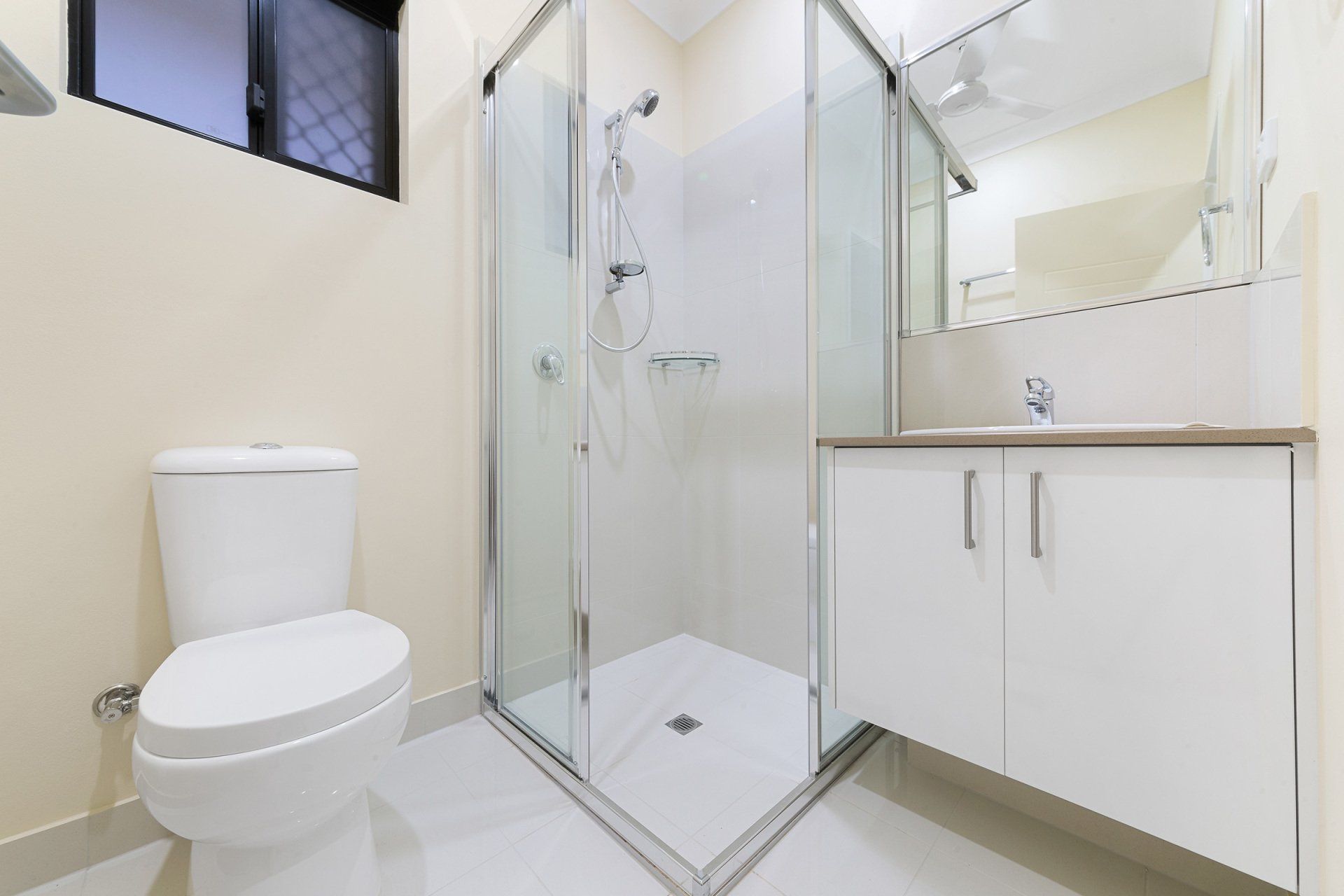 A bathroom with a toilet , sink and shower stall.