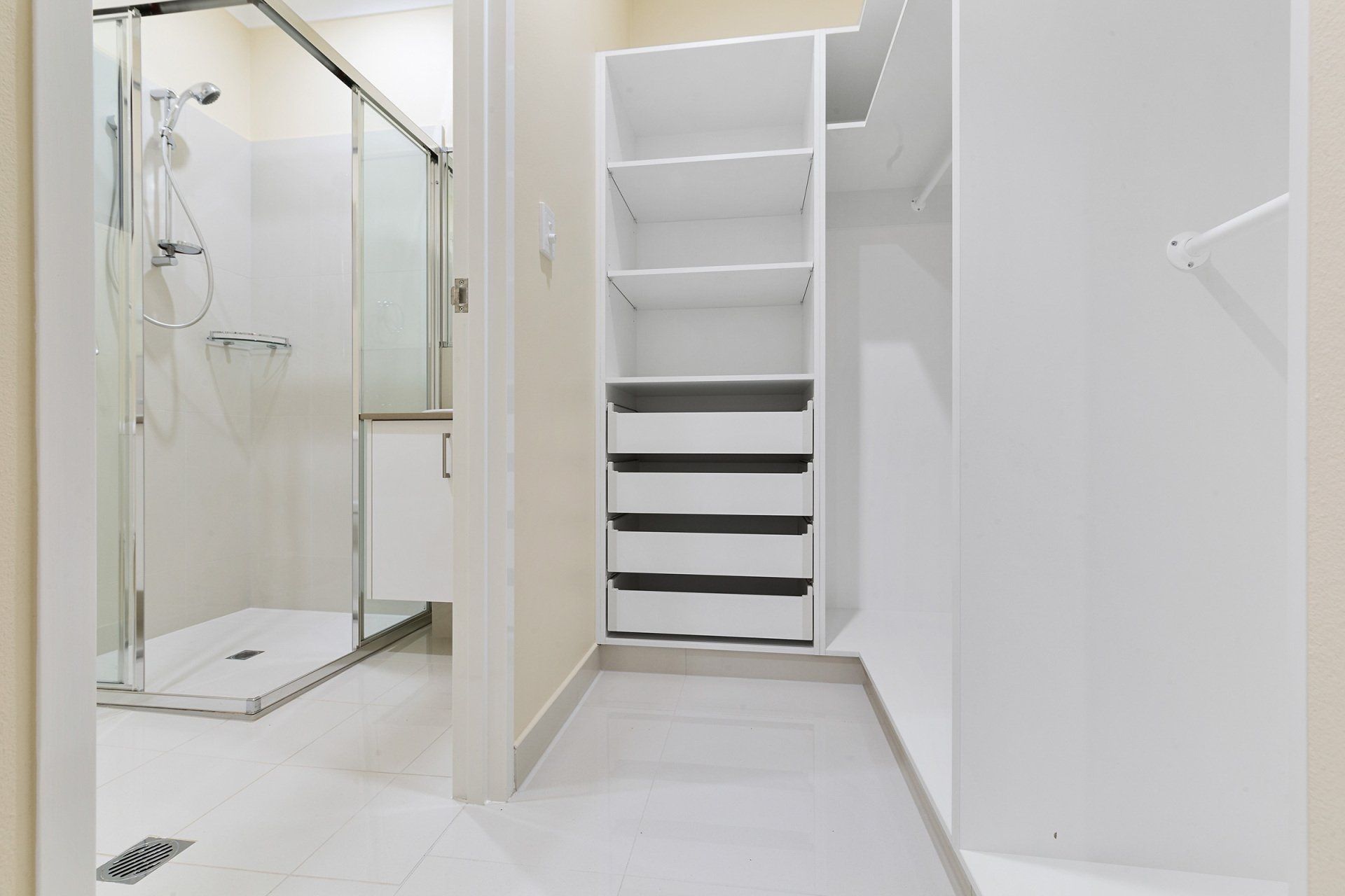 A bathroom with a walk in closet and a shower.