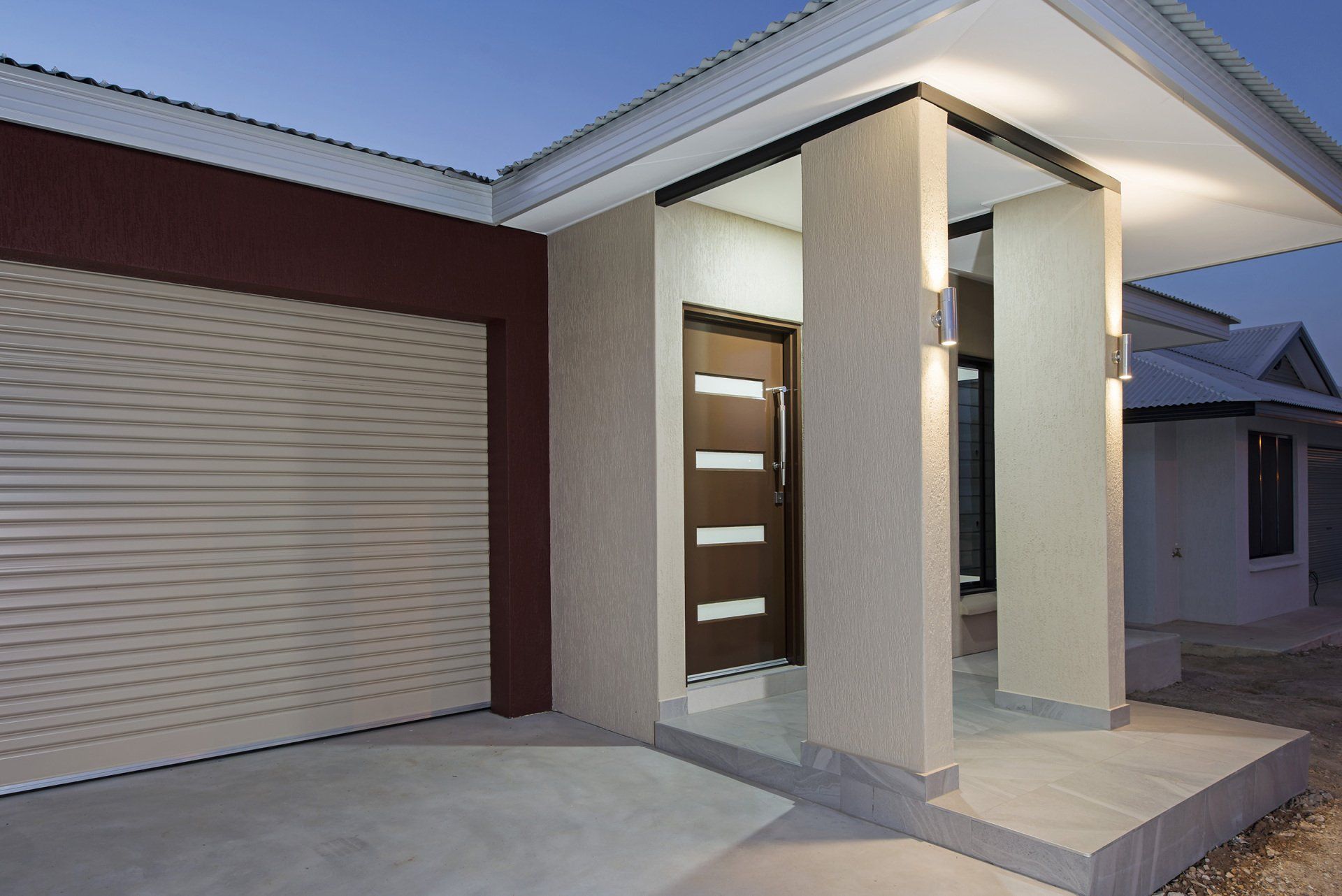 The front of a house with a garage door and pillars