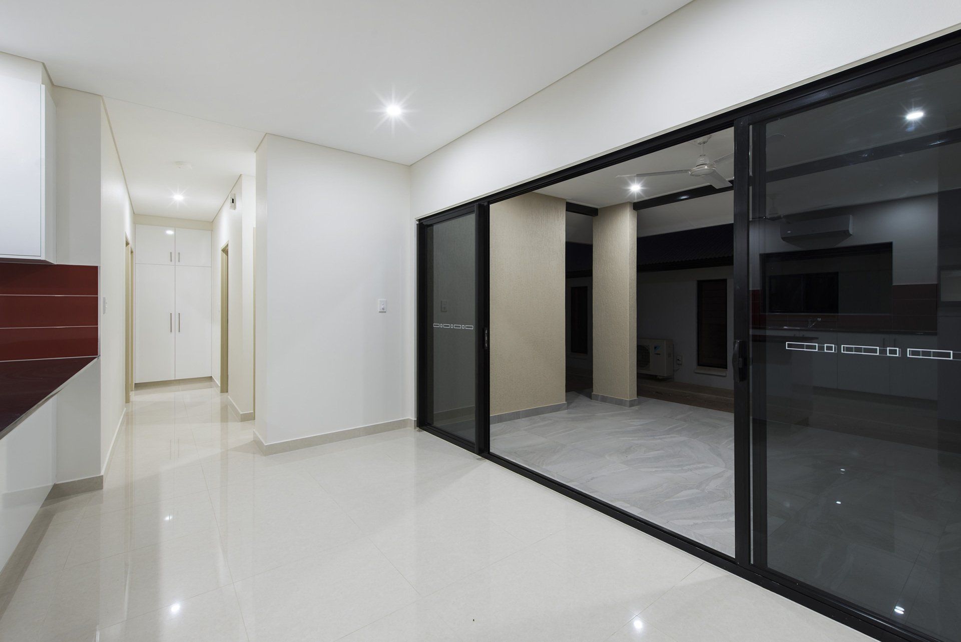 An empty room with sliding glass doors leading to a patio.
