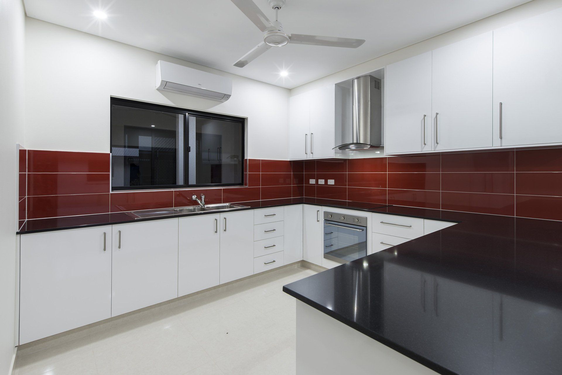 A kitchen with white cabinets and black counter tops