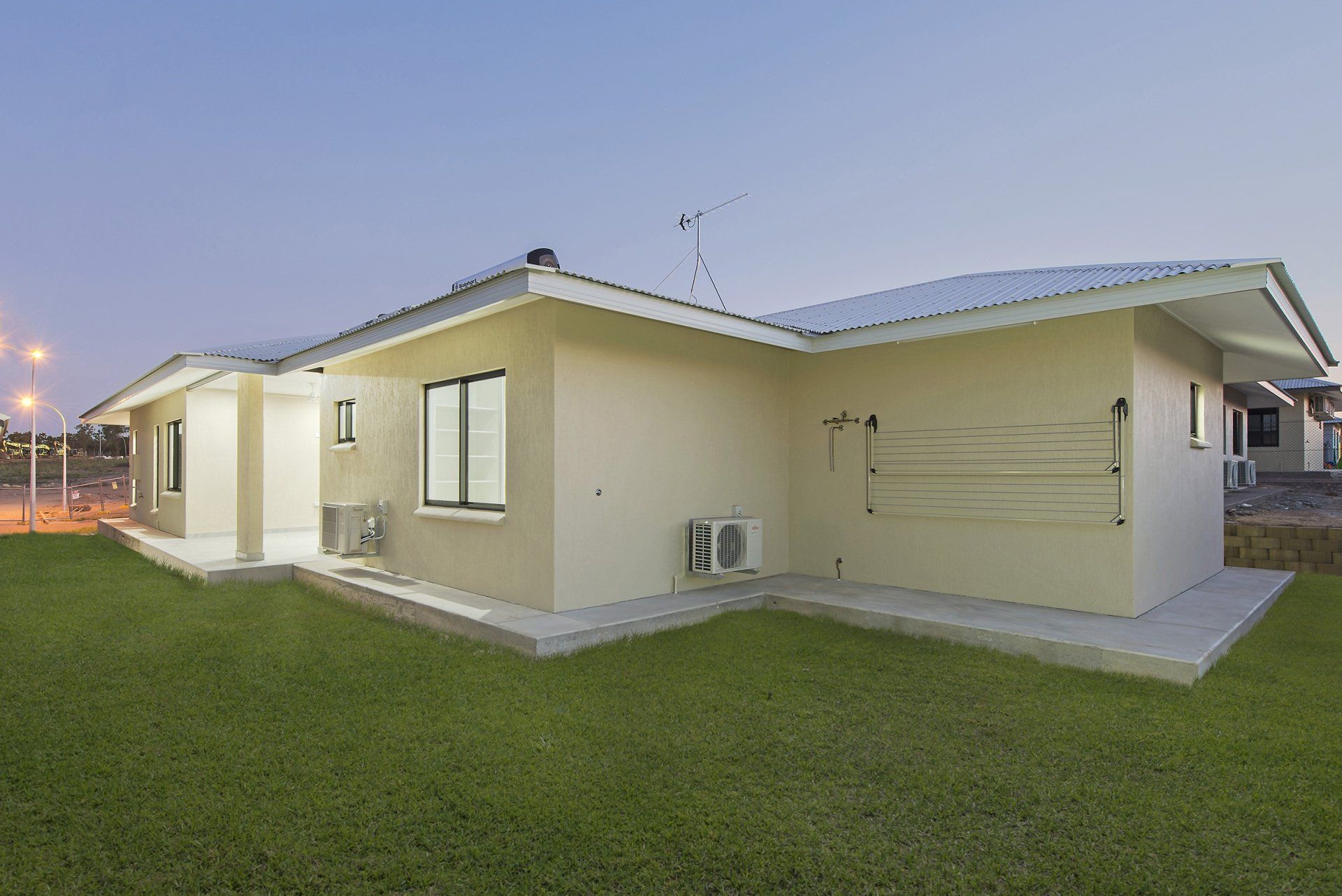 The back of a house with a lawn in front of it.