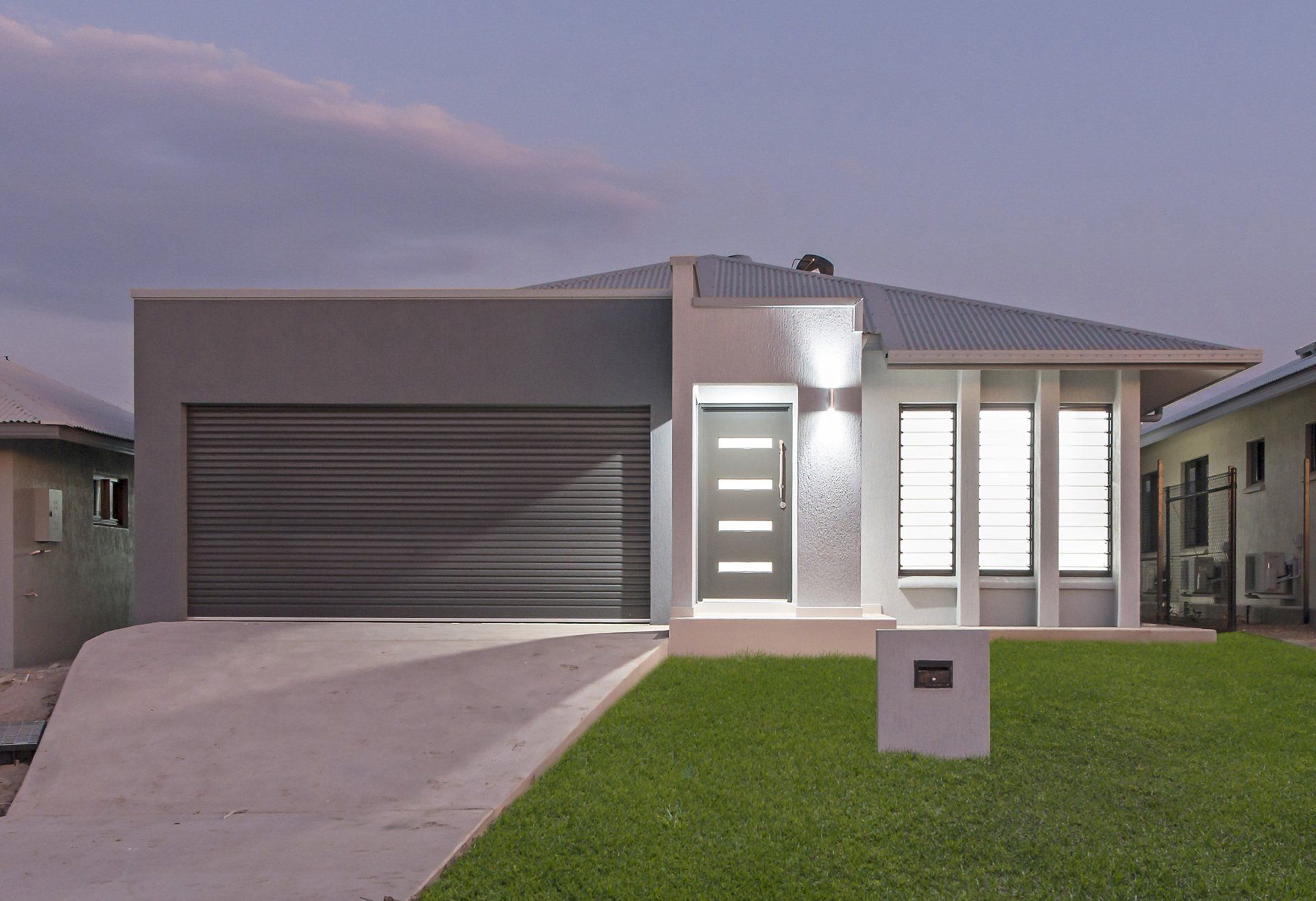 A house with a gray garage door and a white door