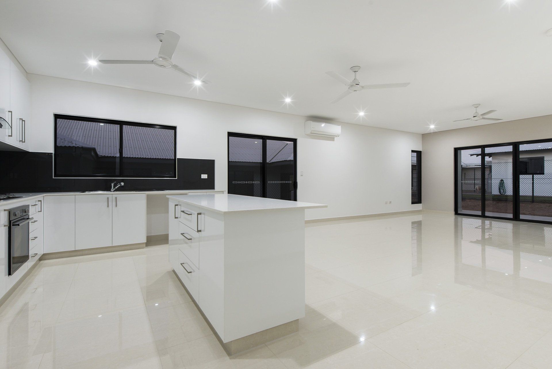 An empty kitchen with a large island in the middle of the room.