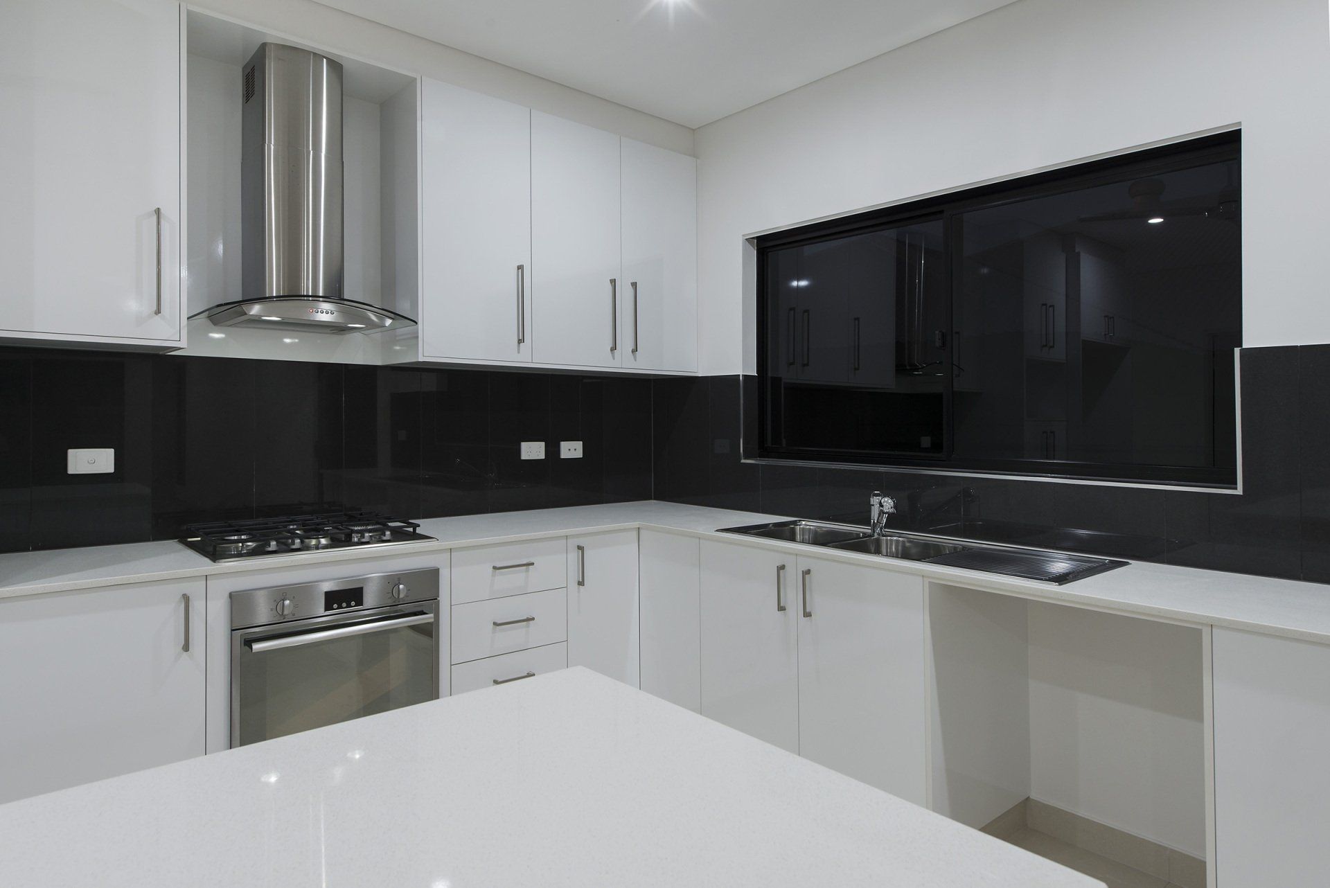 A kitchen with white cabinets and stainless steel appliances