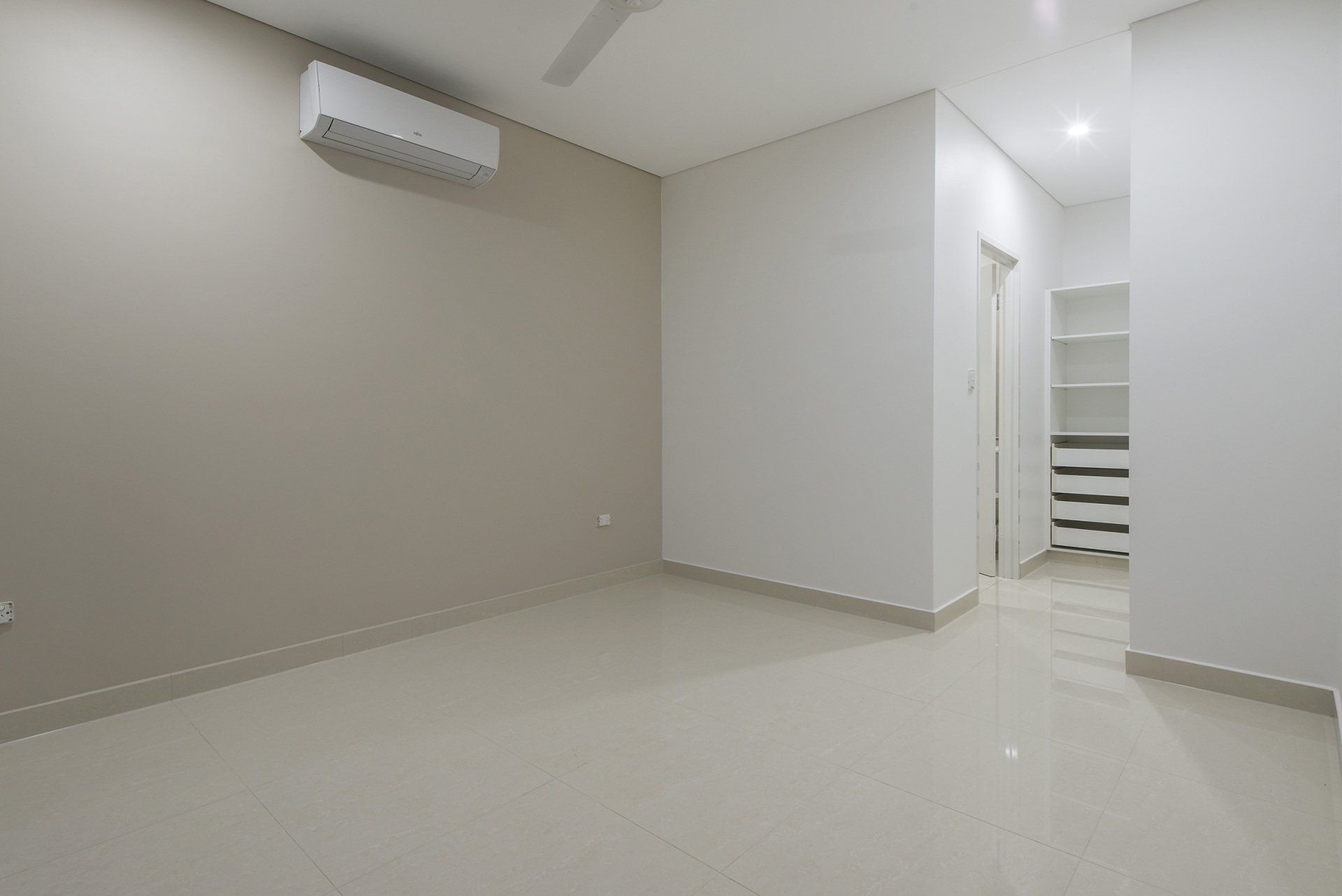 An empty bedroom with a ceiling fan and a walk in closet.