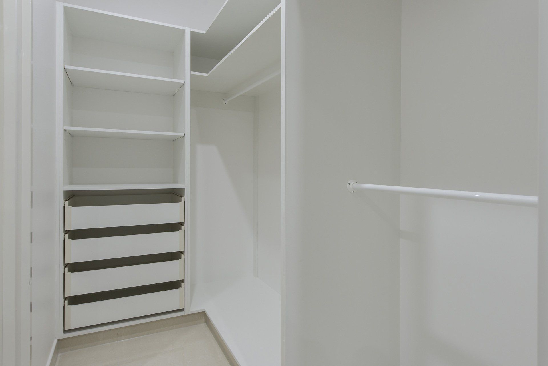 A walk in closet with lots of shelves and drawers.