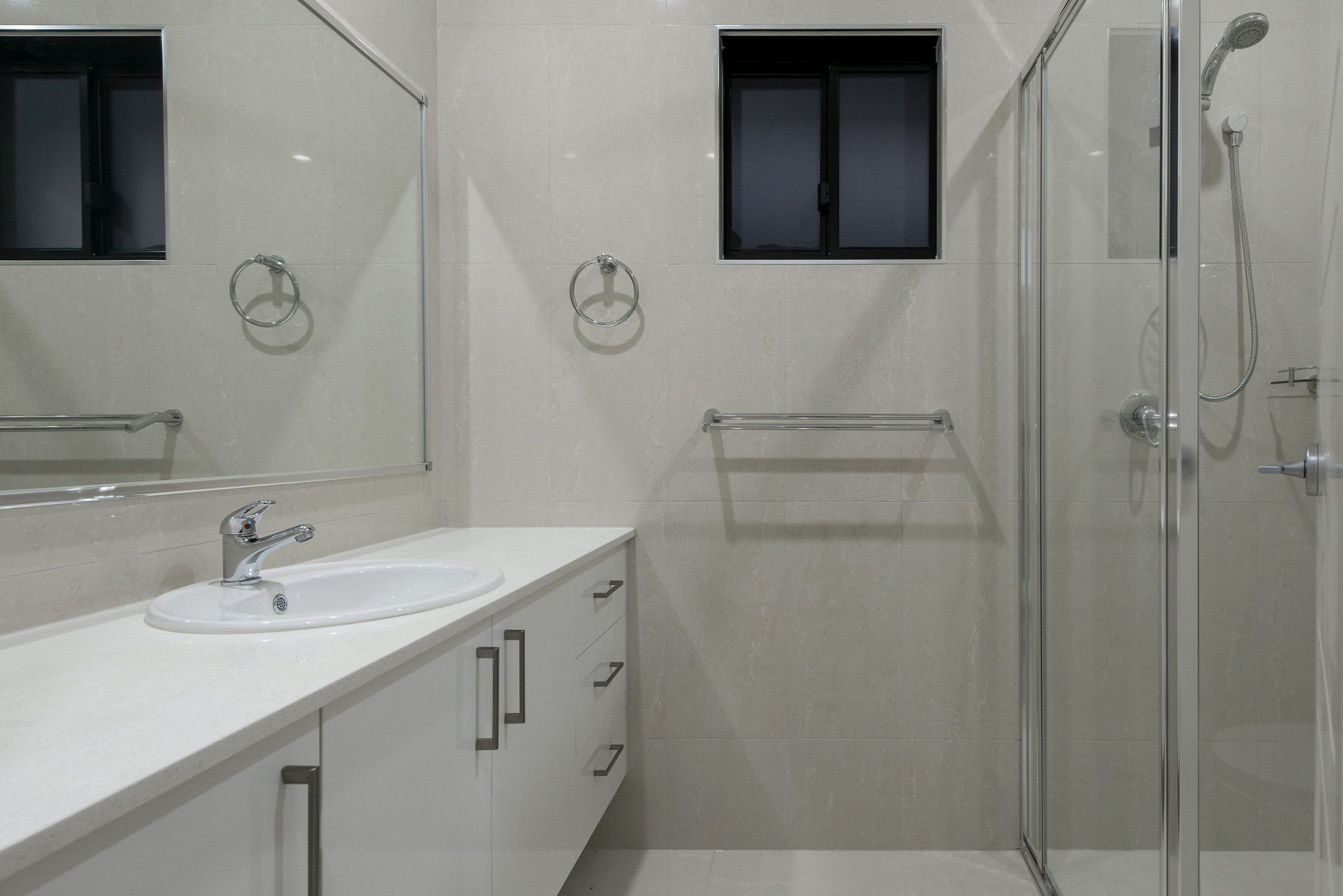 A bathroom with a sink , mirror and shower.