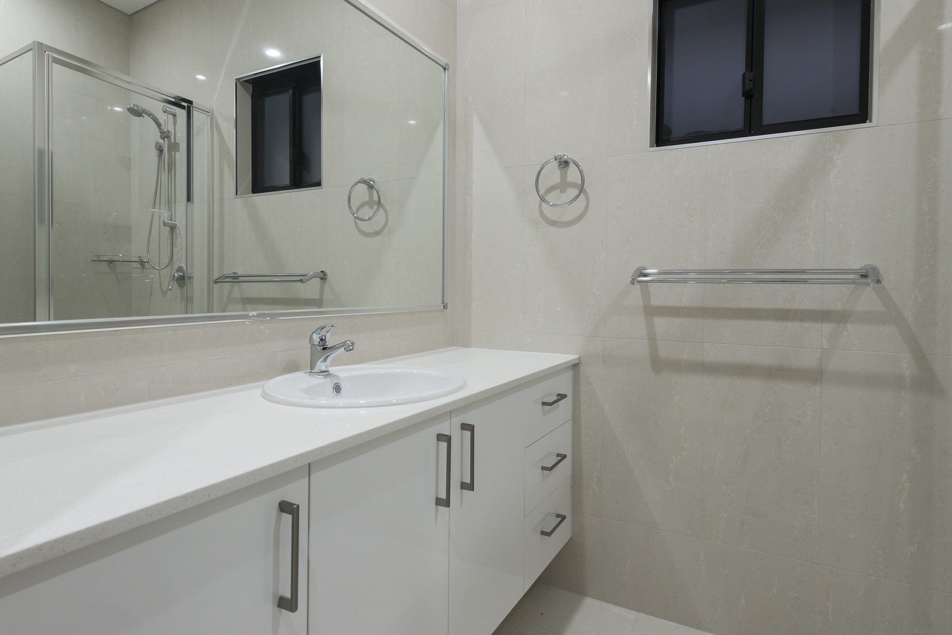 A bathroom with a sink , mirror and shower stall.