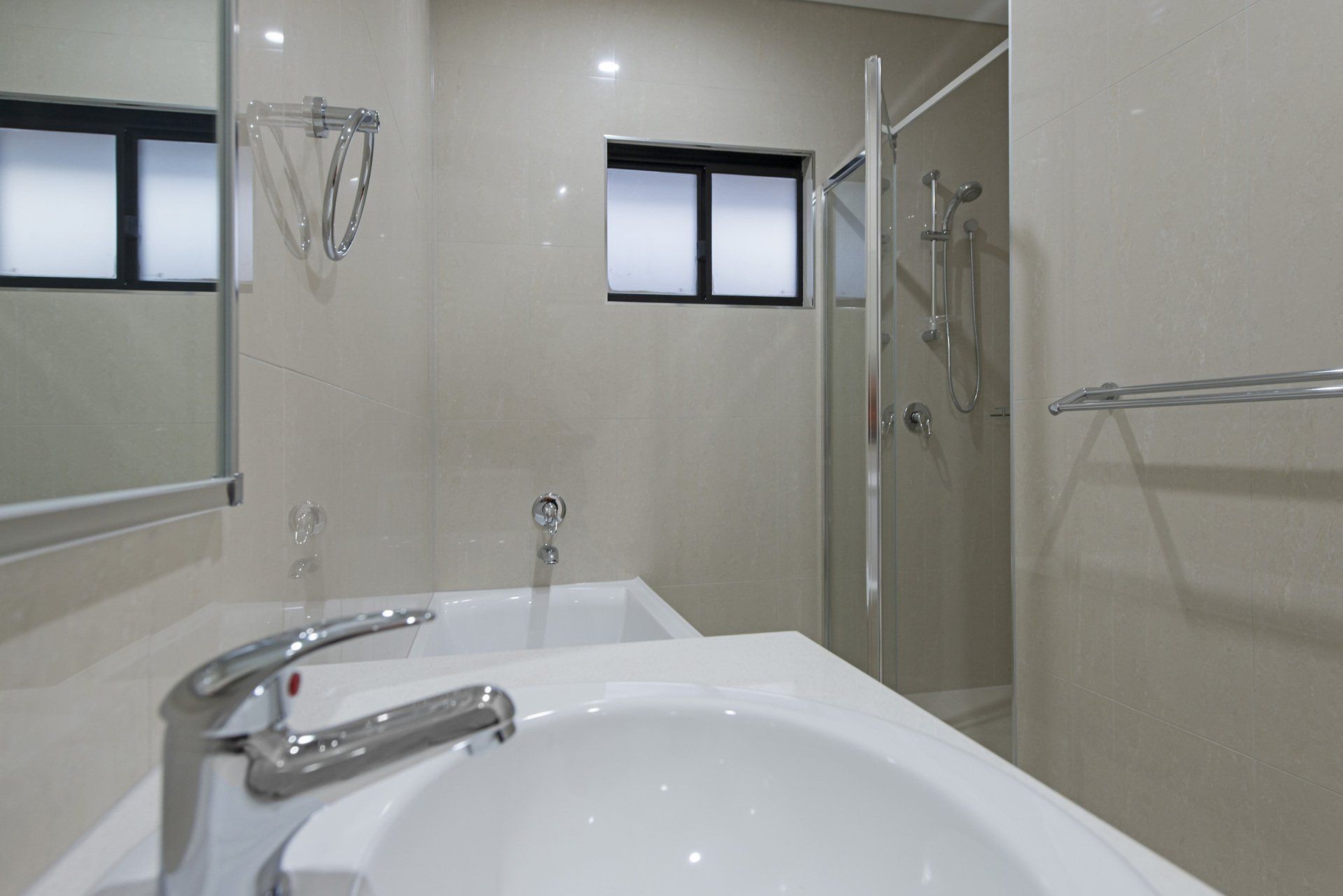 A bathroom with a sink , mirror and shower.