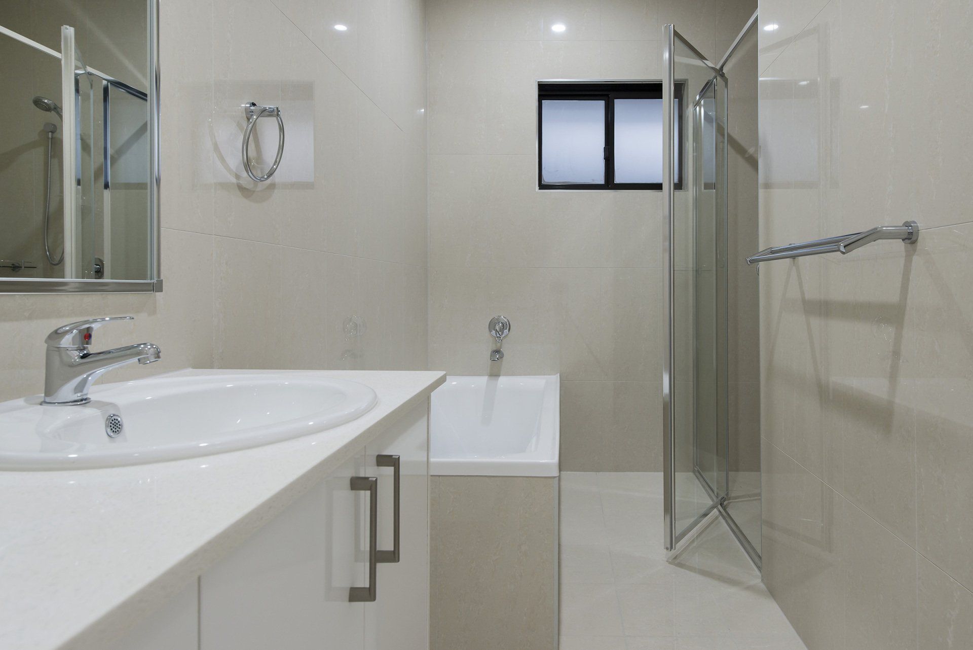 A bathroom with a sink , tub , shower and mirror.