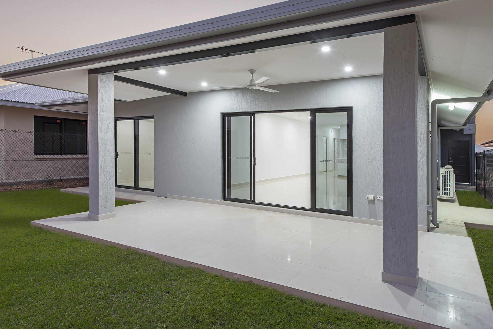 A house with a covered patio and sliding glass doors.