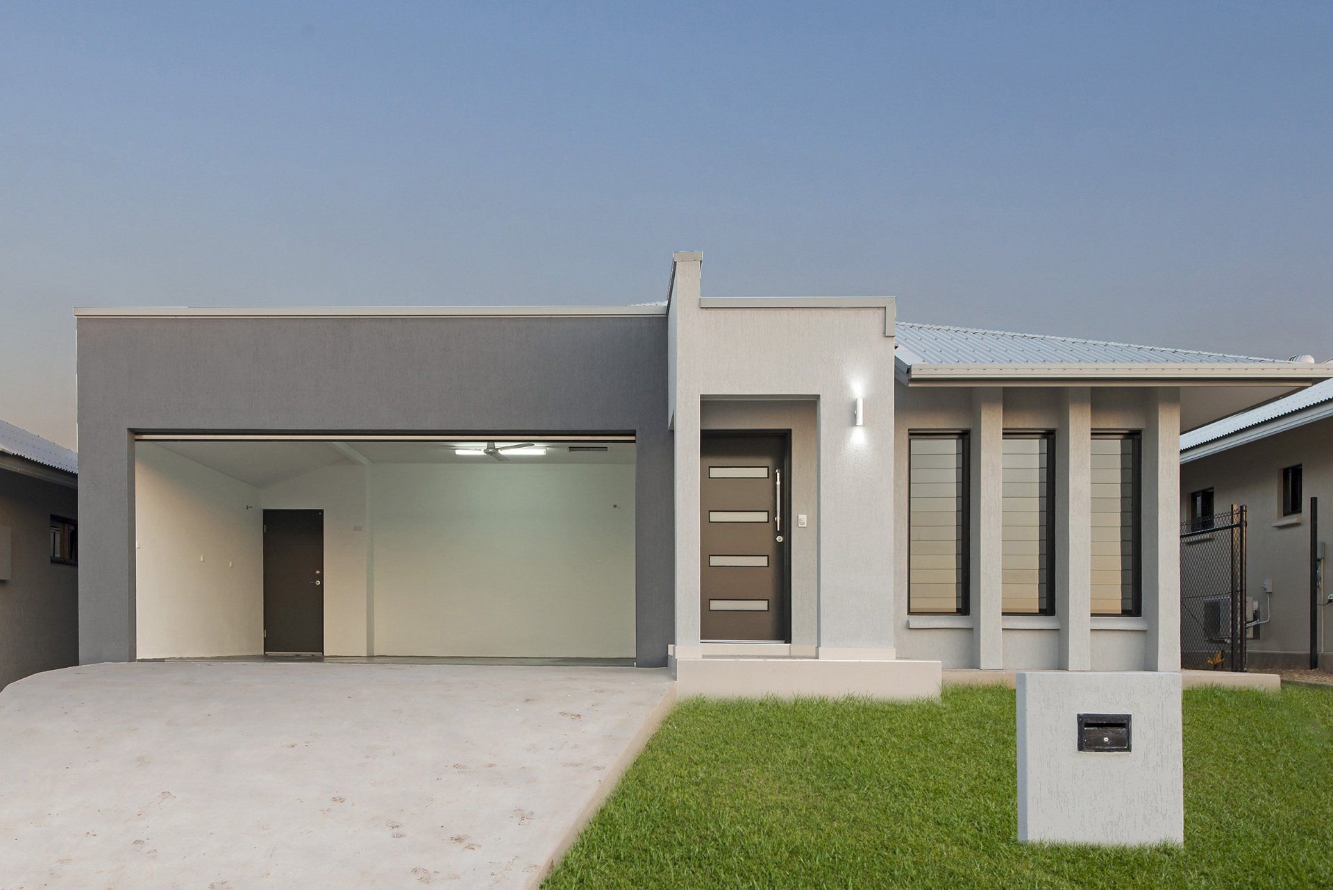 A house with a garage and a mailbox in front of it