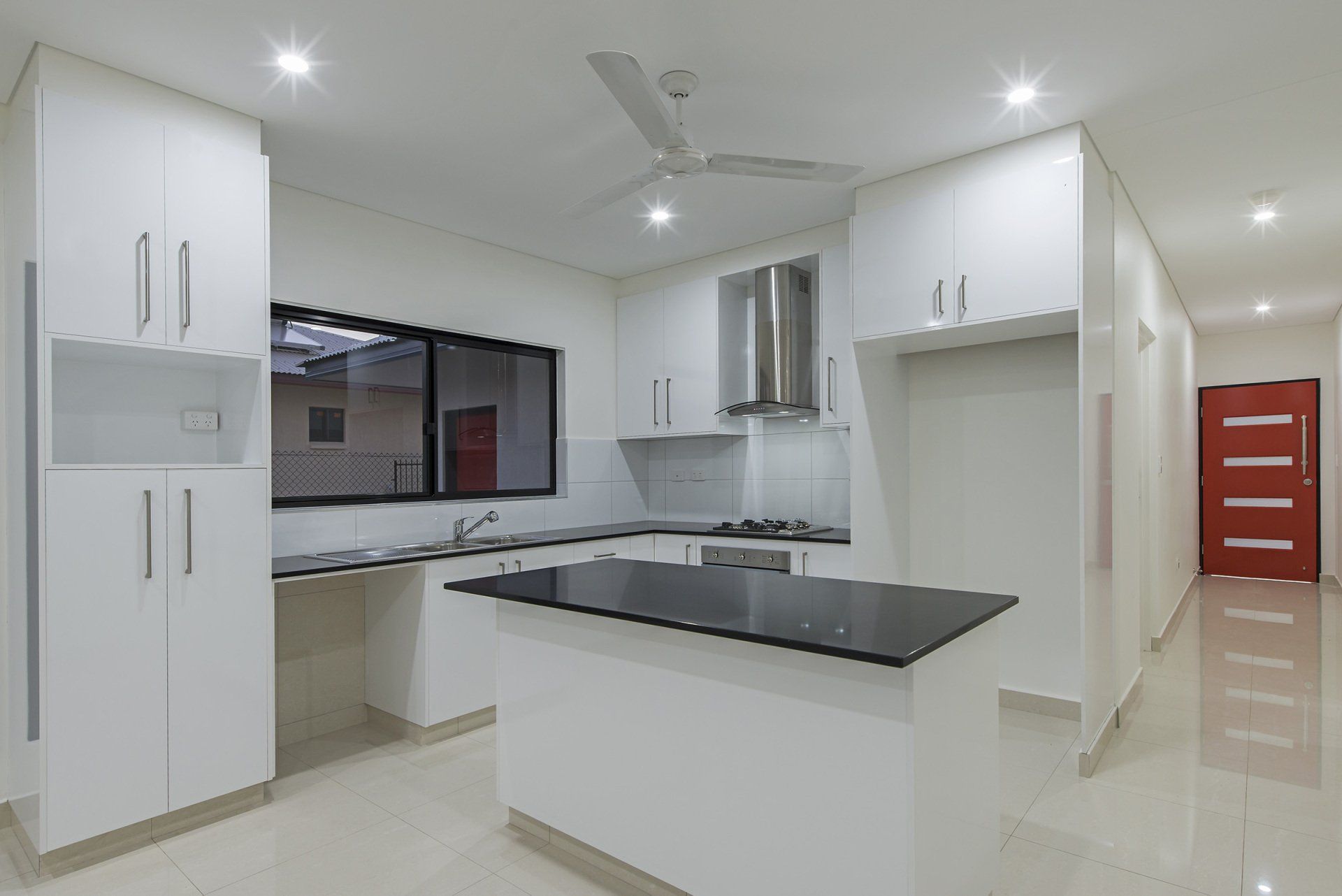 A kitchen with white cabinets and a black counter top