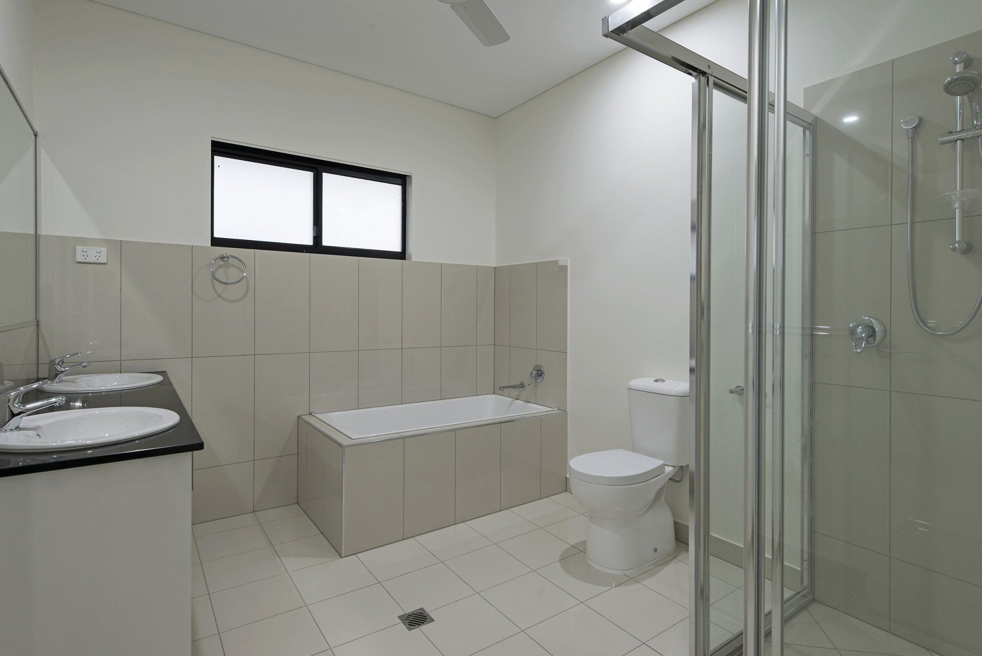 A bathroom with a toilet , sink and shower