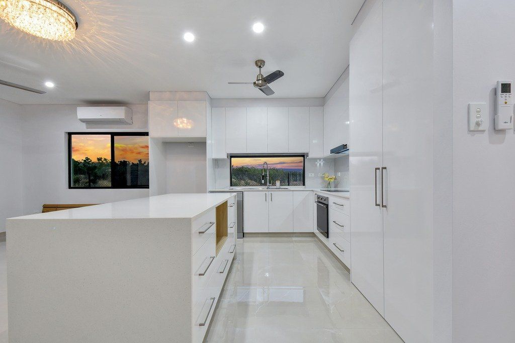 A kitchen with white cabinets and a ceiling fan