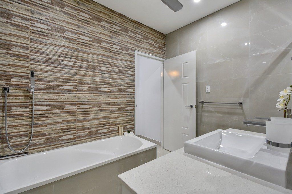 A bathroom with a bathtub , sink and shower.