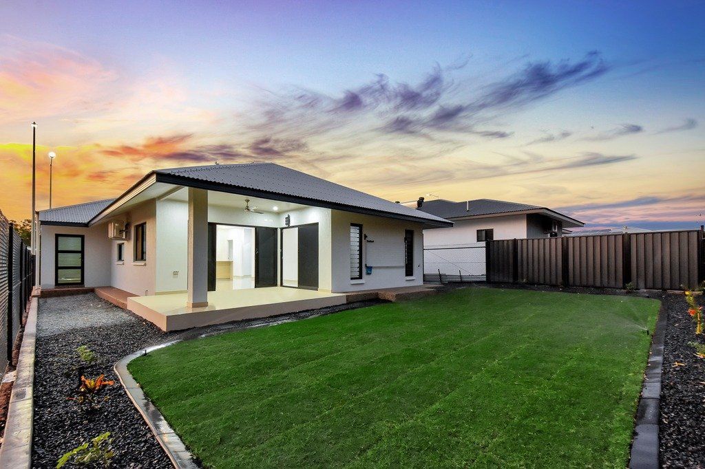 A house with a large lawn in front of it and a fence.