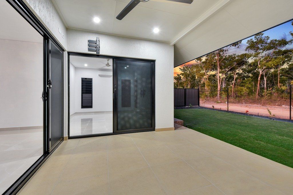 An empty room with sliding glass doors and a ceiling fan.