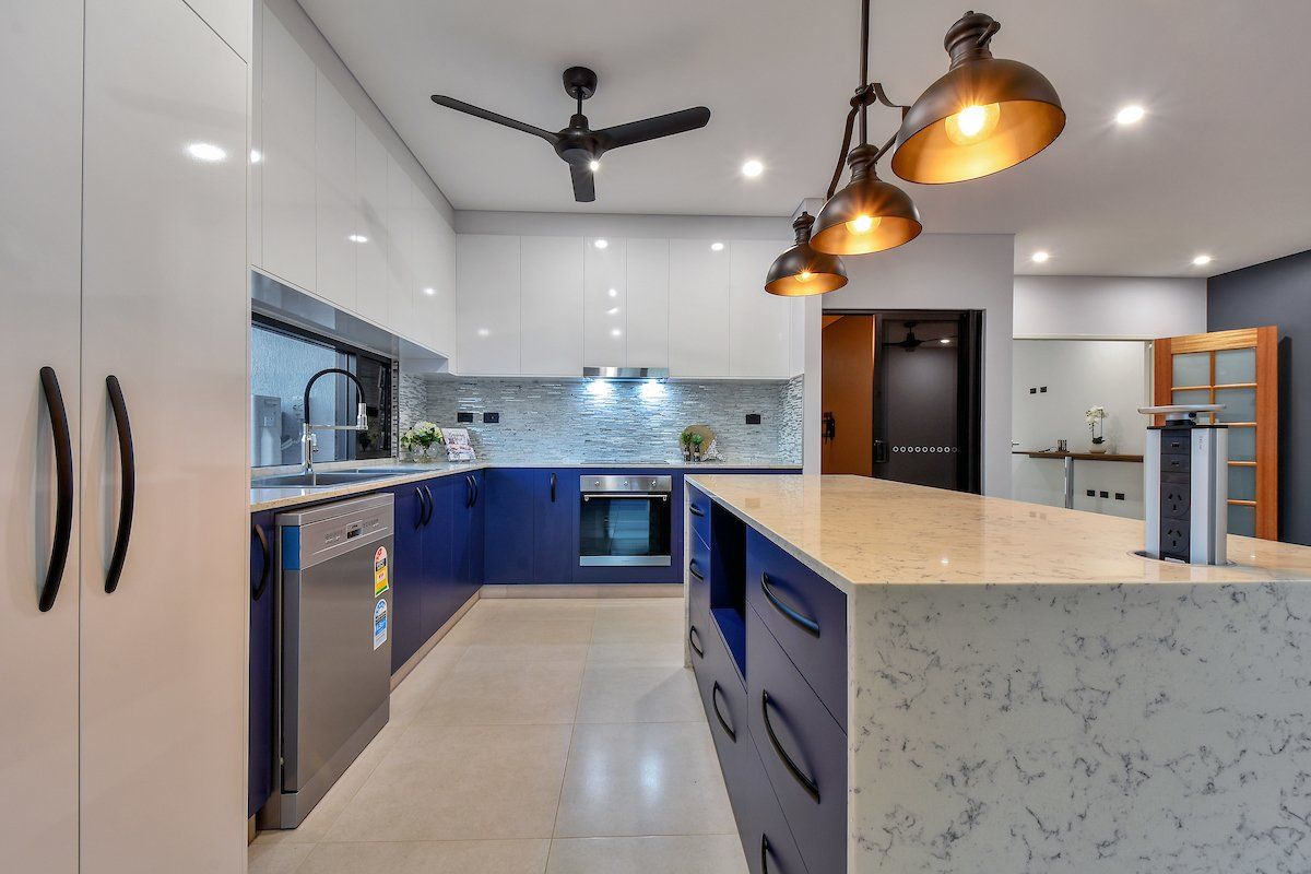 A kitchen with blue cabinets , white cabinets , stainless steel appliances , and a large island.