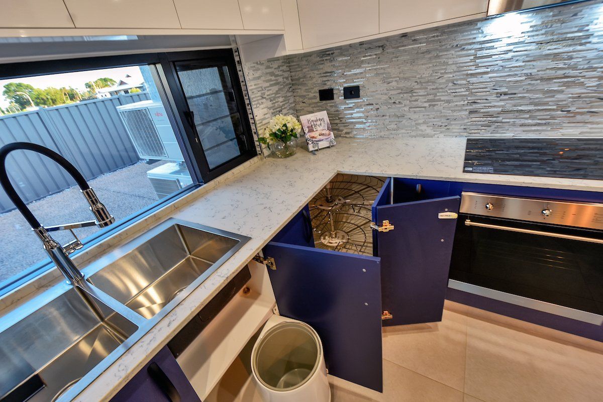 A kitchen with stainless steel appliances and blue cabinets