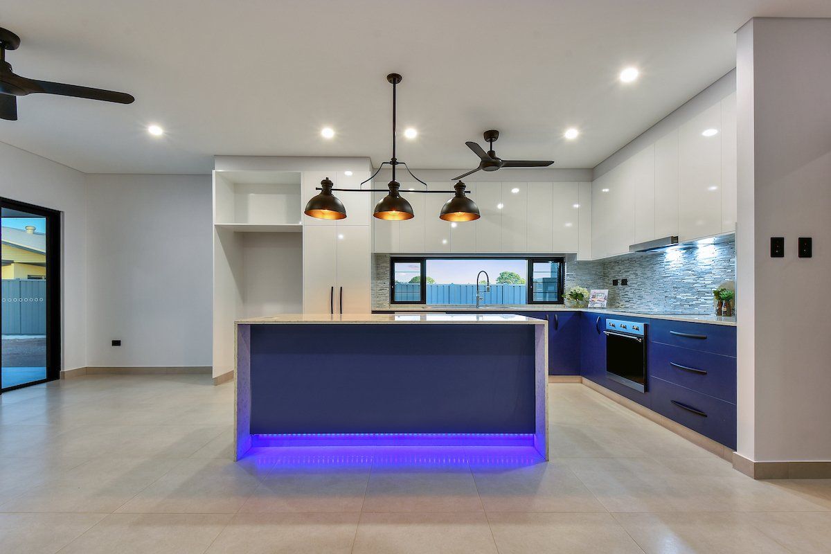 A kitchen with a blue island and a ceiling fan