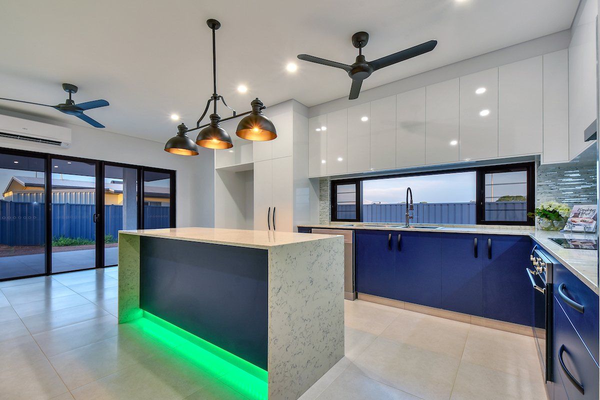 A kitchen with a large island and a ceiling fan.
