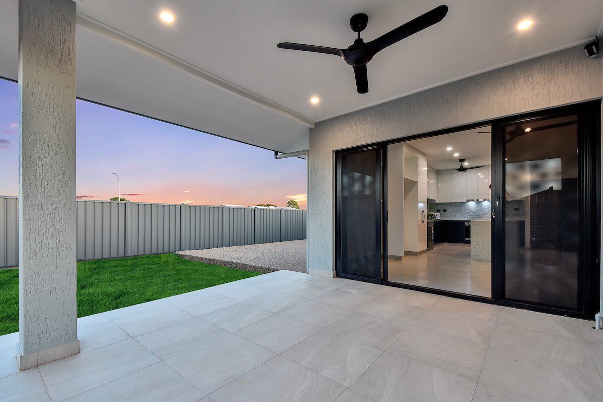 There is a ceiling fan on the patio of a house.