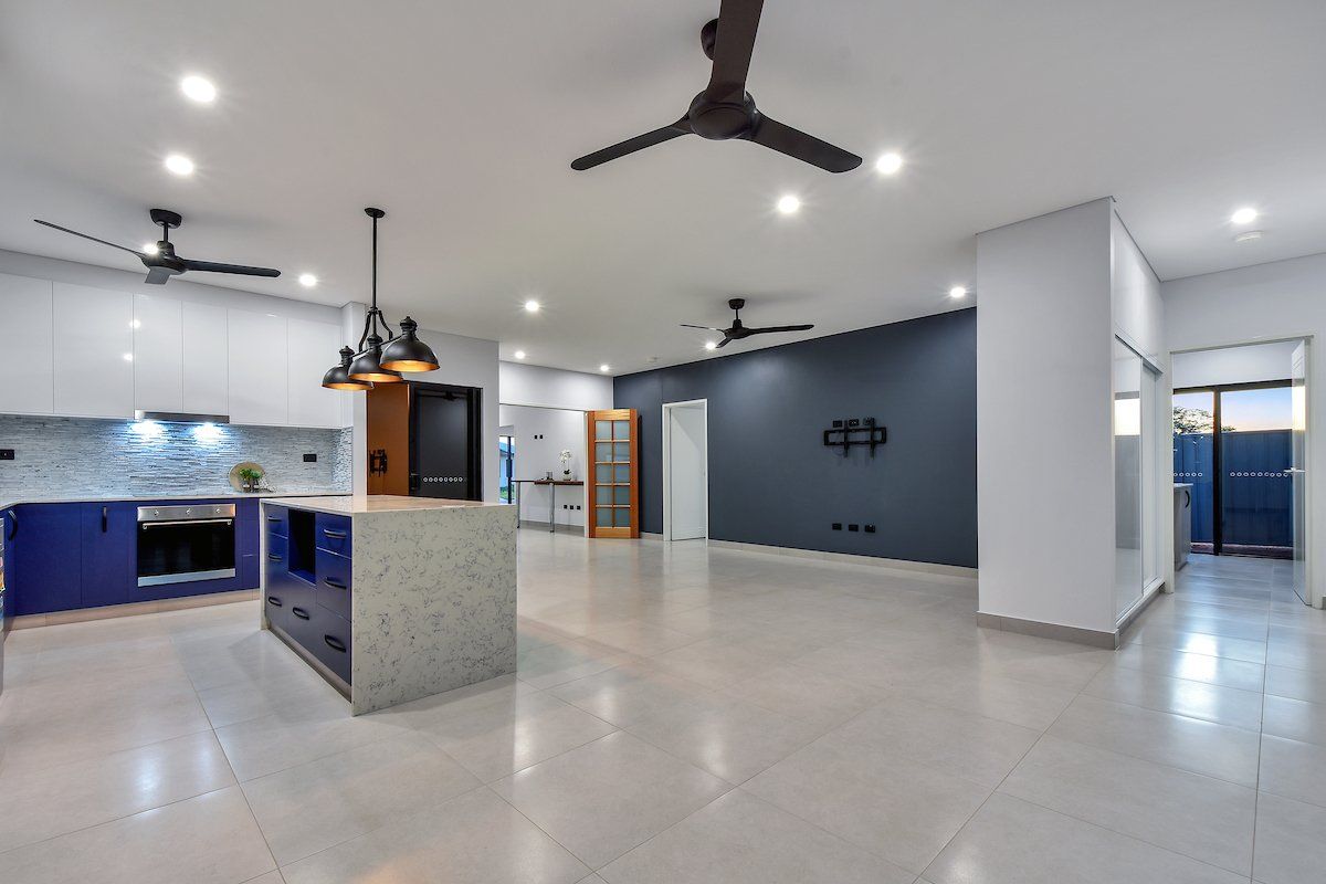 A kitchen with blue cabinets and a ceiling fan