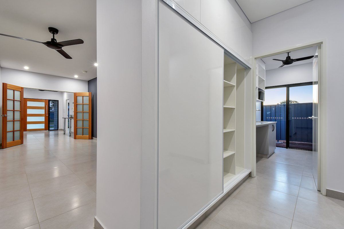 A hallway in a house with sliding glass doors and a ceiling fan.