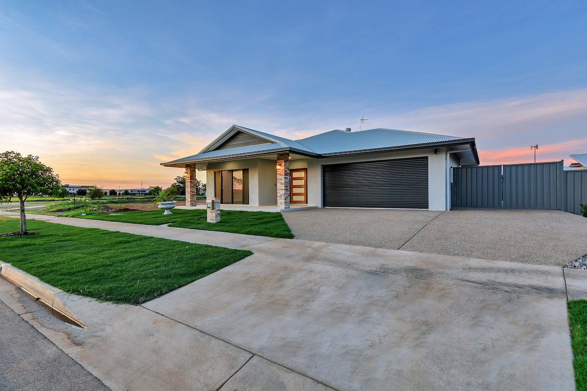 A house with a garage and a driveway in front of it.