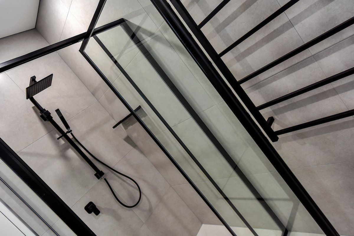 A shower stall with a black frame and a shower head