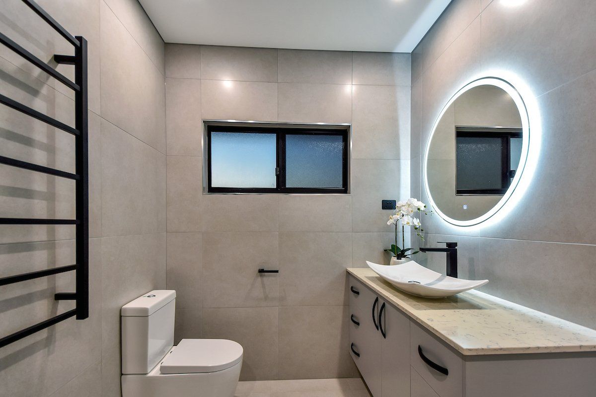 A bathroom with a toilet a sink and a mirror