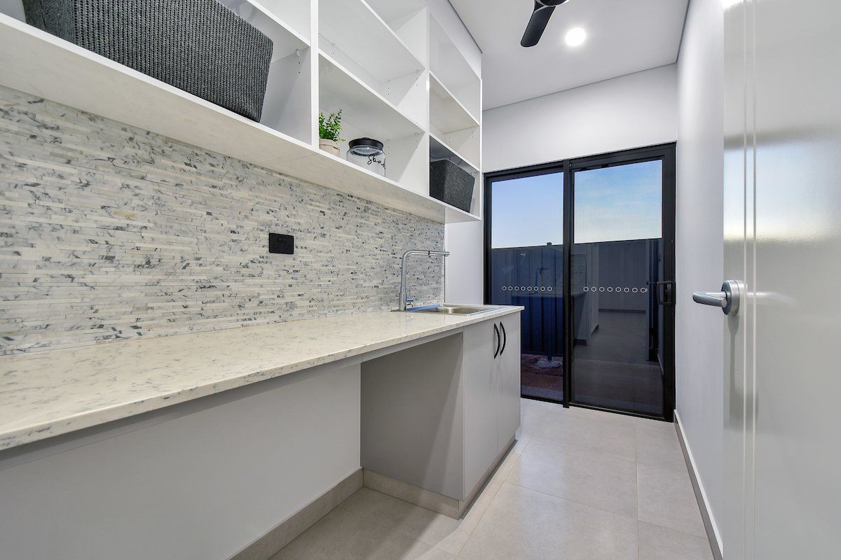 A laundry room with a sliding glass door and a ceiling fan.