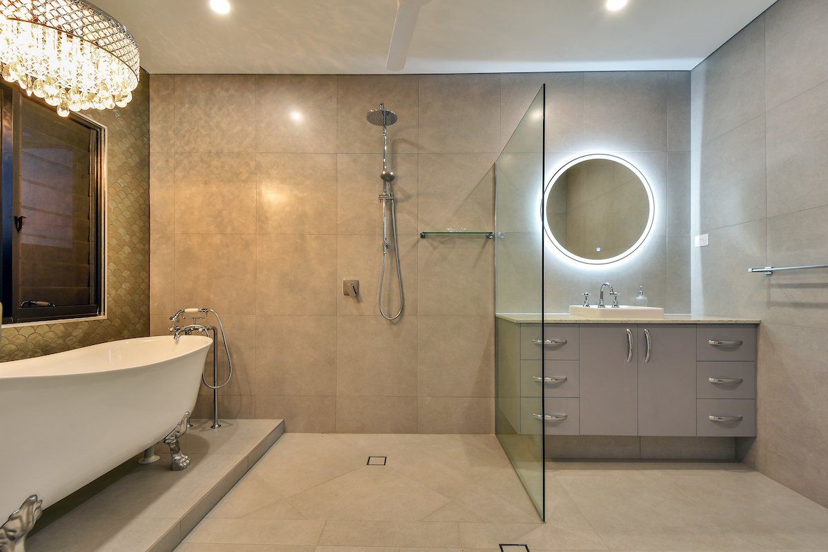 A bathroom with a bathtub , sink , shower and mirror