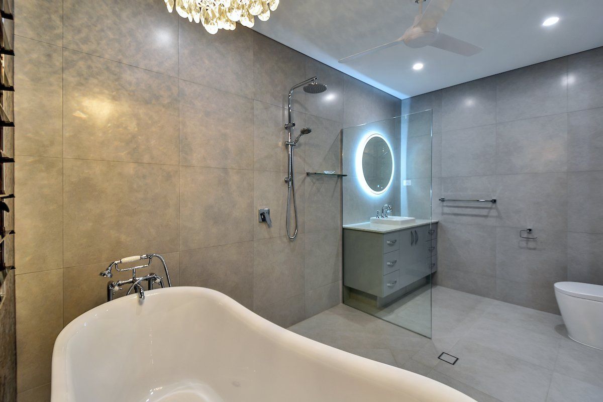 A bathroom with a bathtub , sink , toilet and shower.