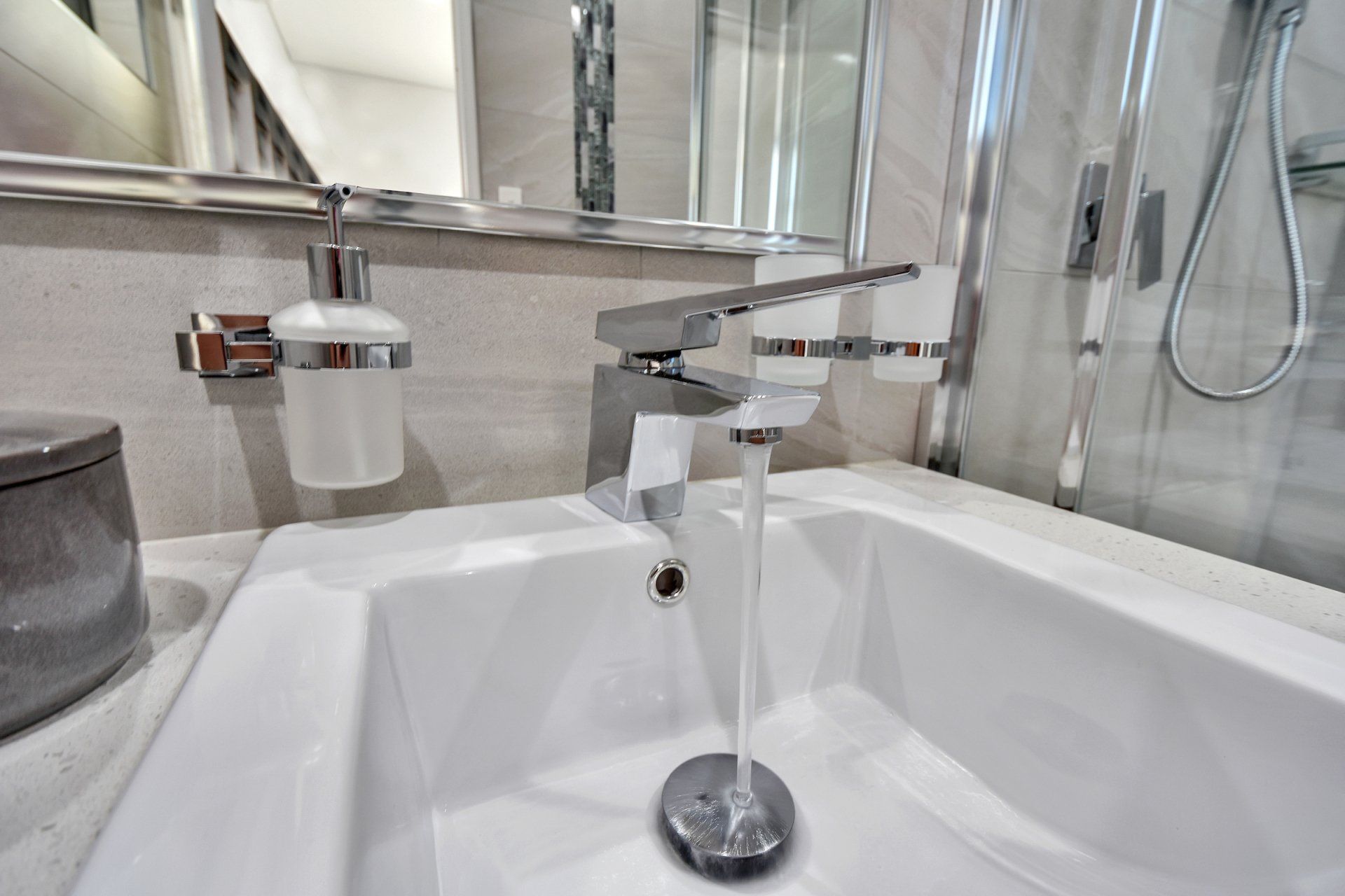 A bathroom sink with water running from the faucet.