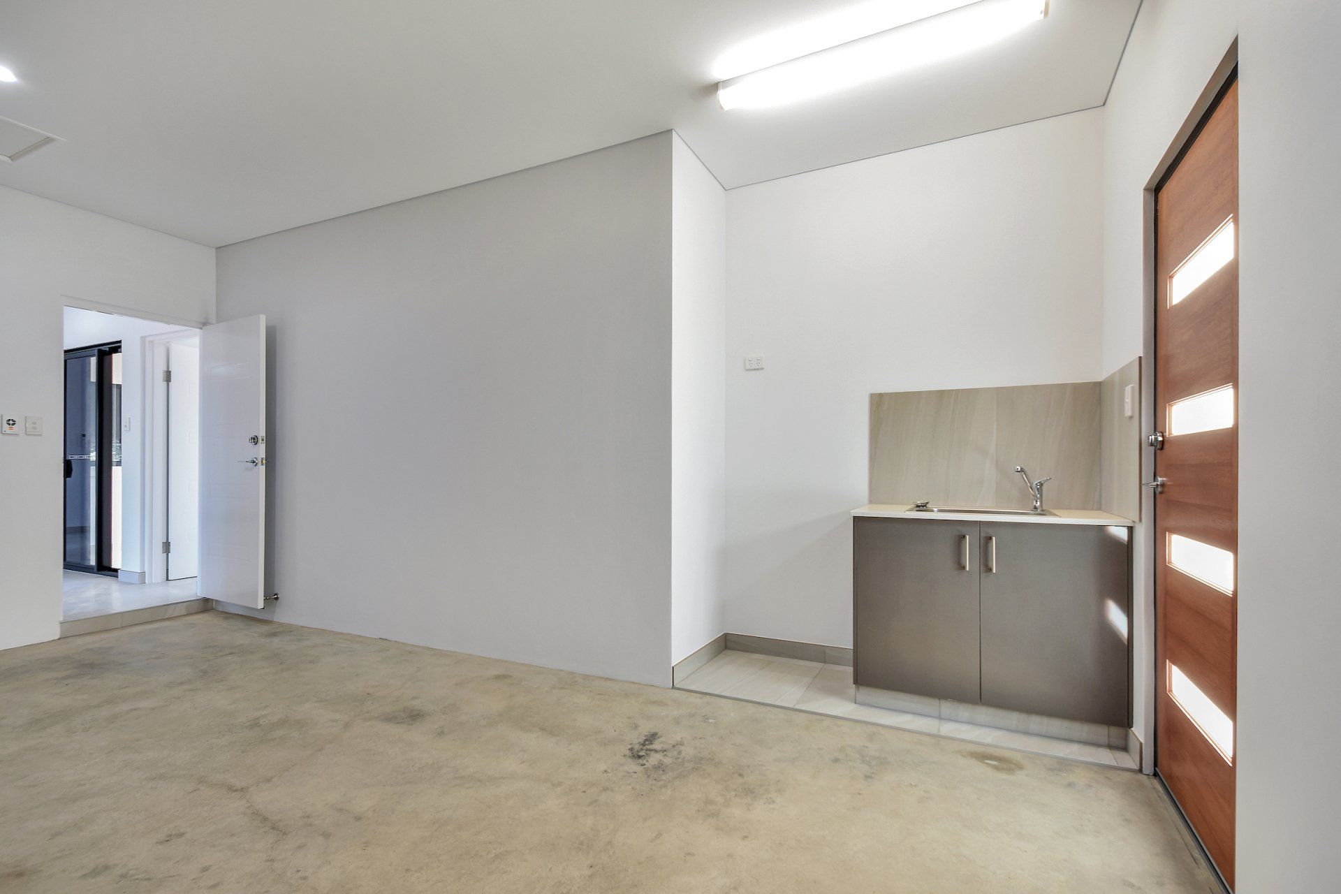 An empty room with a sink and cabinets in it