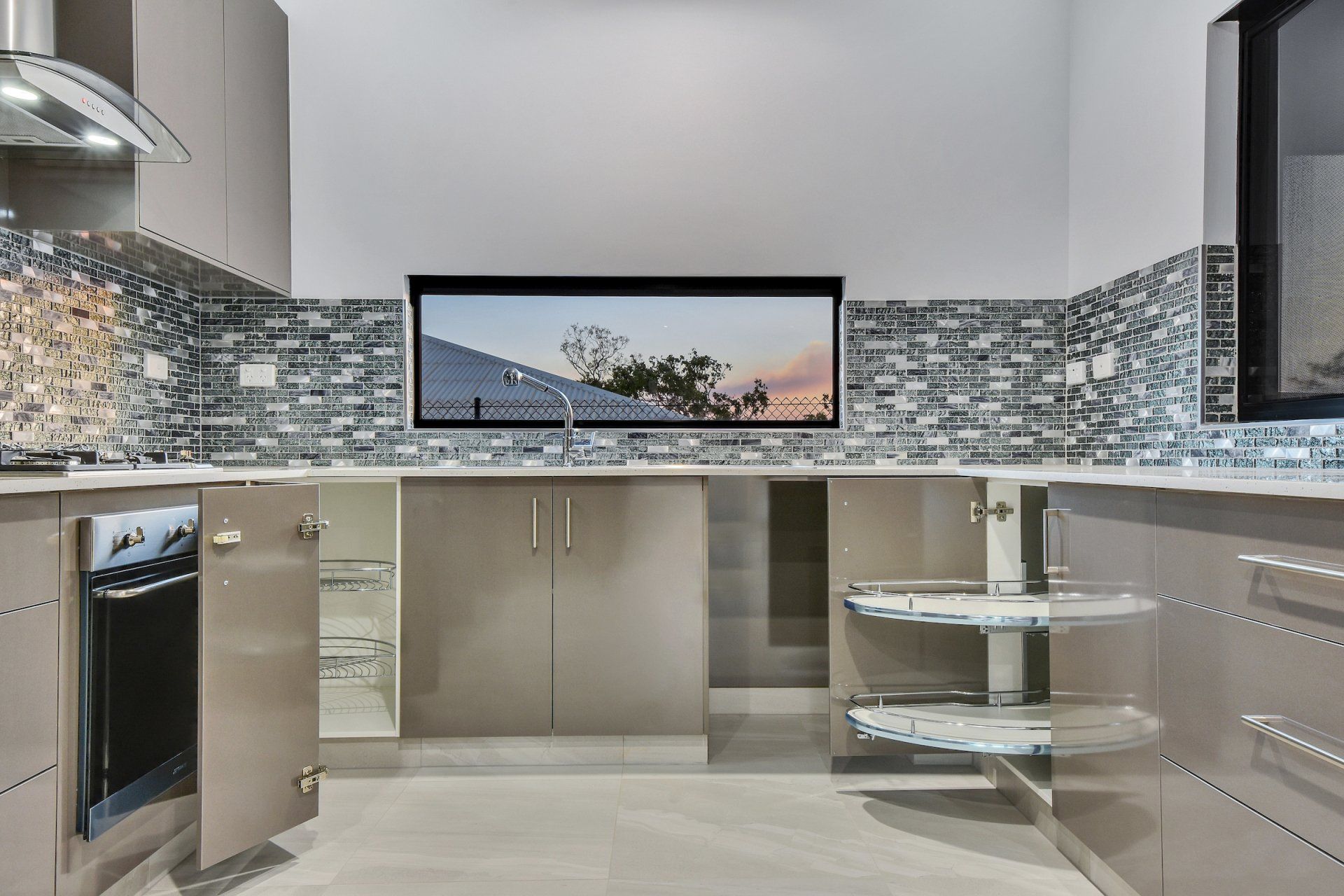 A kitchen with stainless steel cabinets and a flat screen tv on the wall.